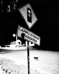 Close-up of road sign at night