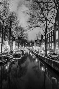 Canal amidst buildings in city against sky