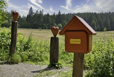 Information sign on wooden post in field against sky