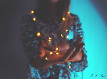 Close-up of hand holding illuminated lighting equipment