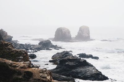 Rocks on beach against sky