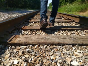 Low section of people walking on railroad track
