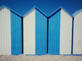 Huts at beach against clear sky