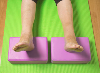 Low section of woman relaxing on exercising mat
