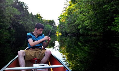 Young man adjusting fishing rod