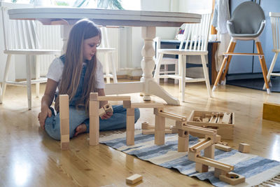 Young woman sitting on table at home