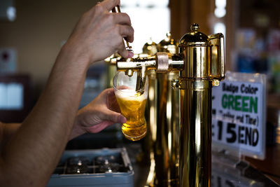 Close-up of hand serving beer