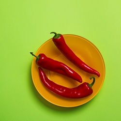 Close-up of red chili peppers on green background