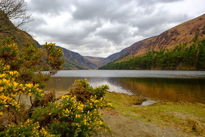 Scenic view of lake by mountains against sky