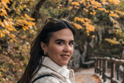 Portrait of beautiful young woman hiking on path in autumn forest.