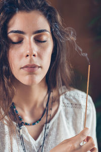 Young woman holding burning incense