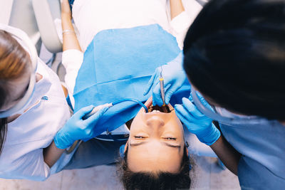 Dentists examining woman in clinic