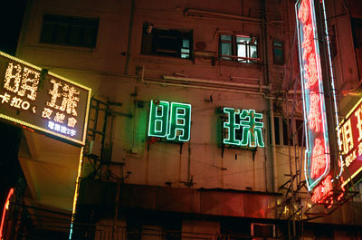 Low angle view of illuminated text on building at night