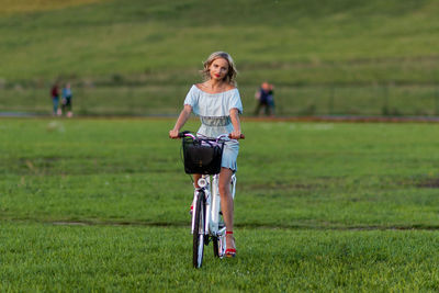 Woman riding bicycle on field