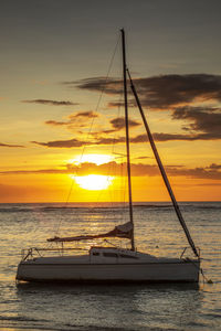 Sailboat sailing on sea against sky during sunset