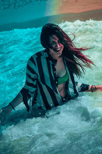 Young woman smiling while standing in sea