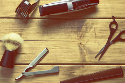 Directly above shot of shaving equipment on wooden table