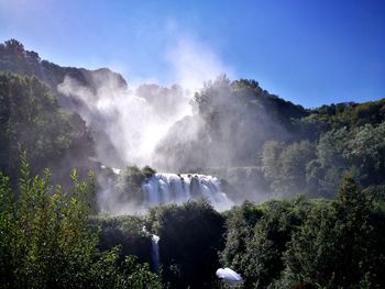 Panoramic view of waterfall in forest against sky