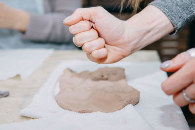 Cropped hand of person preparing food on table