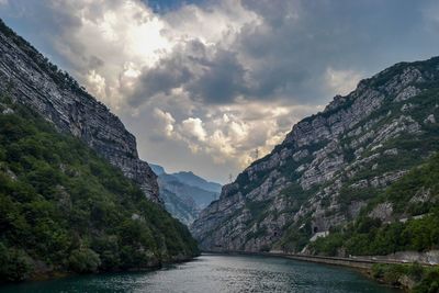 Scenic view of river amidst mountains against sky