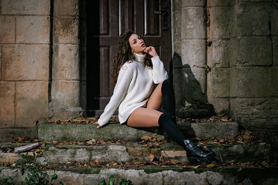 Portrait of woman sitting on wall