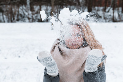 Rear view of woman holding snow