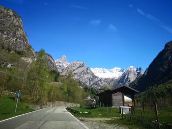 Road by mountains against blue sky