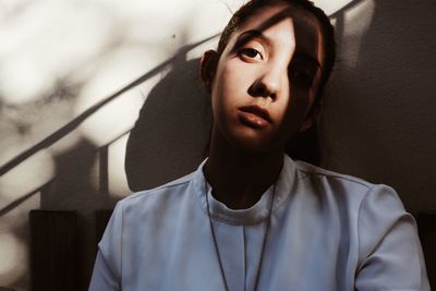 Close-up portrait of young woman standing at home