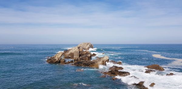 Scenic view of rock formation in sea against sky