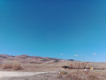 Scenic view of desert against clear blue sky