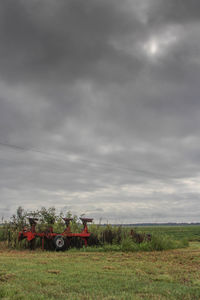 Scenic view of grassy field against cloudy sky