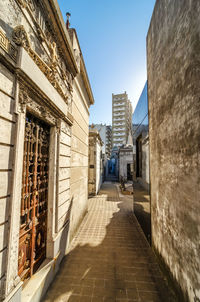 Footpath amidst buildings in city against clear sky