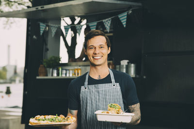 Portrait of a smiling young man holding food