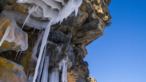 Low angle view of rock formations against blue sky