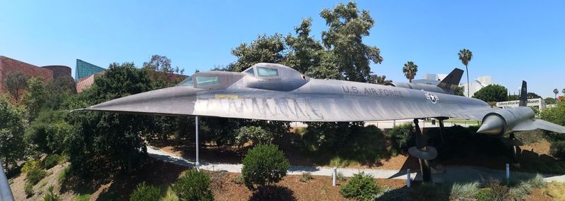 Built structure by trees against clear blue sky