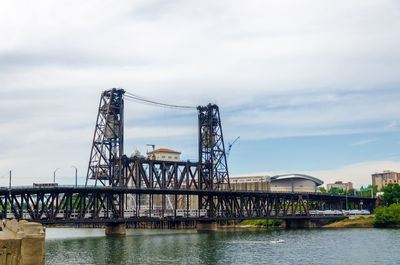 Low angle view of cranes at harbor against sky