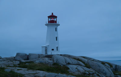 Lighthouse by sea against sky