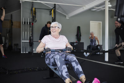 Smiling senior woman exercising in gym