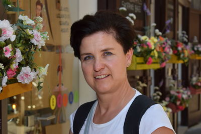 Portrait of smiling woman by flower bouquets