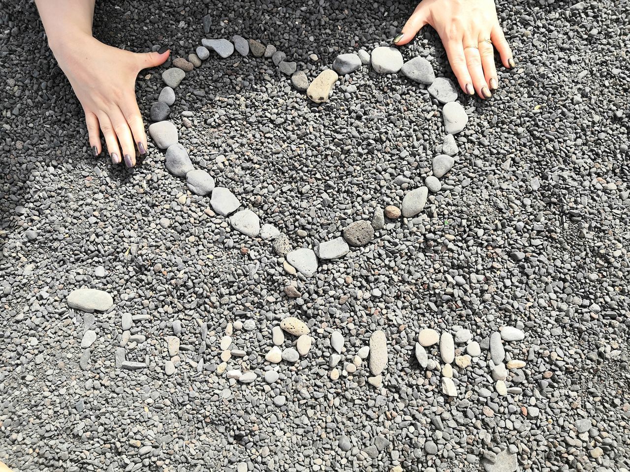 HIGH ANGLE VIEW OF HUMAN HAND ON STONE