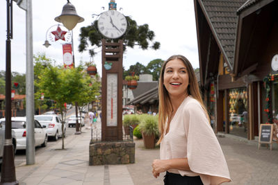 Portrait of young woman standing in city