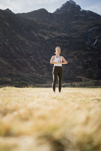 Woman performing yoga poses in alpine mountain landscape, gastein, austria