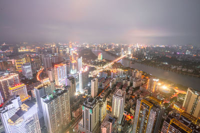 High angle view of illuminated cityscape against sky at night