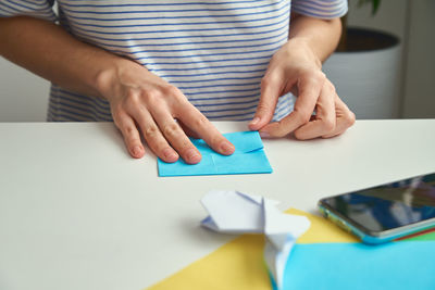 Origami lessons. woman make origami easter rabbit from color paper. diy concept