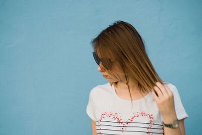 Woman standing against blue wall