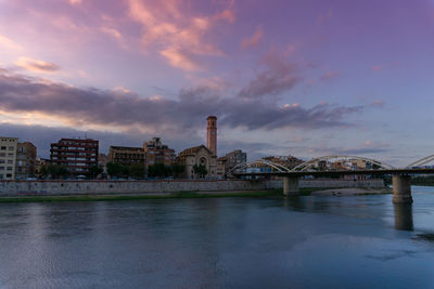 Bridge over river against buildings in city