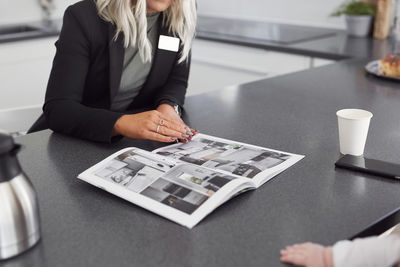 Female estate agent showing house brochure