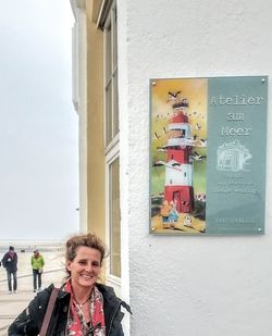 Portrait of smiling woman in city against sky