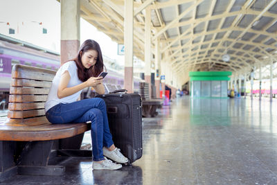 Young woman sitting on chair at airport