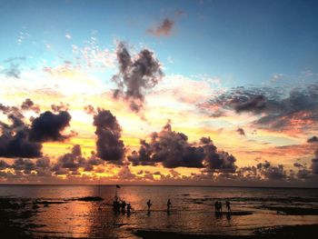 Silhouette trees by sea against sky during sunset